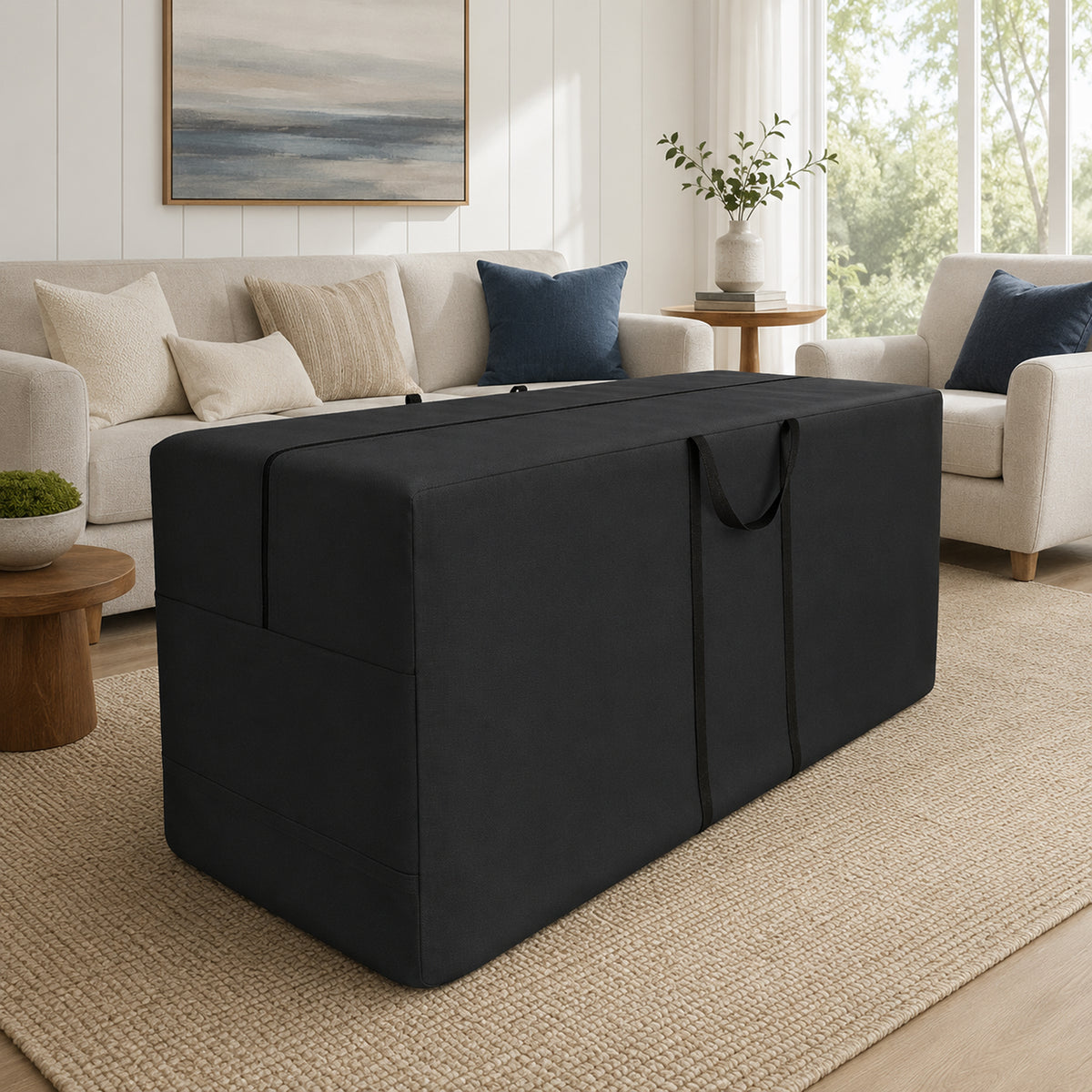 A black fabric storage ottoman or trunk with carry handles, shown in a bright, modern living room setting next to a beige sofa and armchair. - view 3