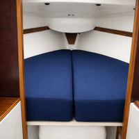 Two blue mattresses inside a wooden cabinet.