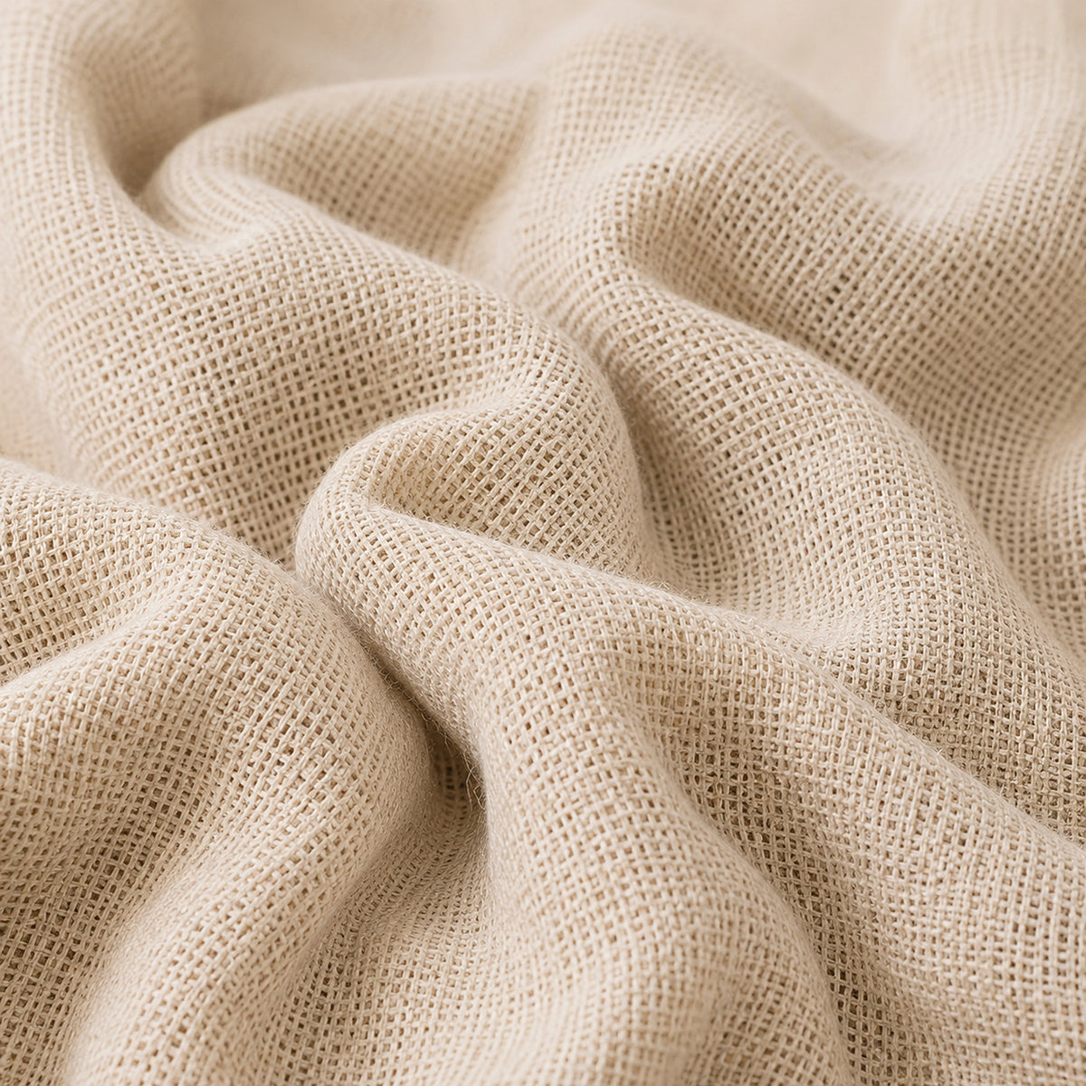 A close-up of draped beige woven fabric with a visible open-knit texture, shown in soft folds against a matching neutral background.