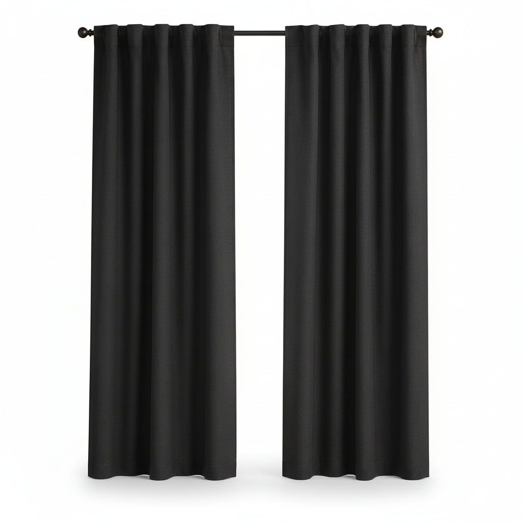 A pair of black grommet-top curtain panels hanging on a black rod in front of a window, shown in a room with a light beige wall and light wood floor.