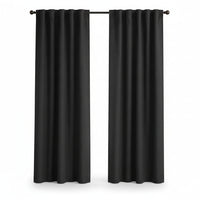 A pair of black grommet-top curtain panels hanging on a black rod in front of a window, shown in a room with a light beige wall and light wood floor.