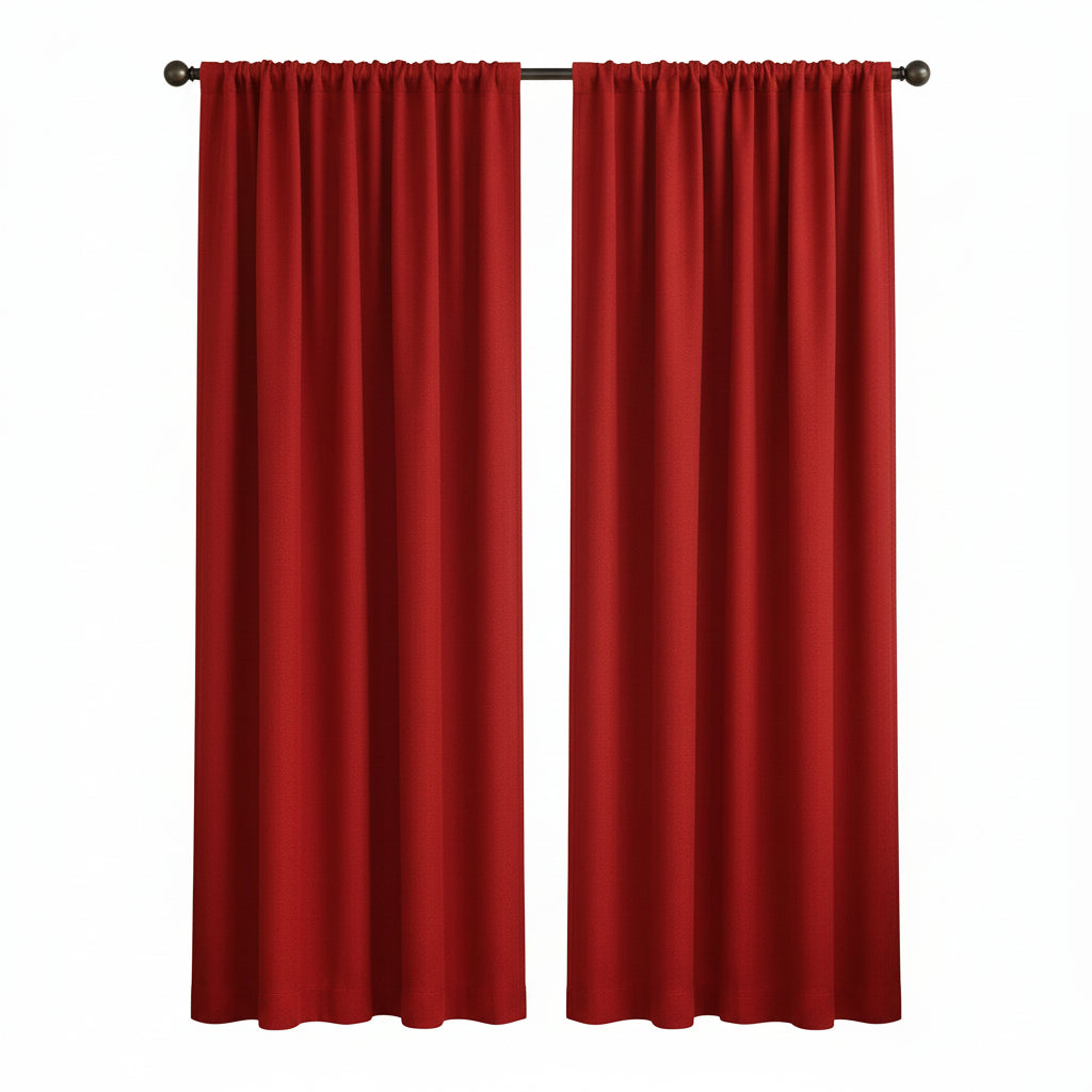 A pair of bright red curtain panels hanging on a black rod over a window in a styled living room with a beige armchair, side table, and plant.