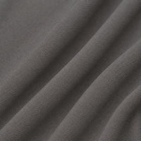 A close-up of dark gray woven fabric with soft diagonal folds showing the textile texture.