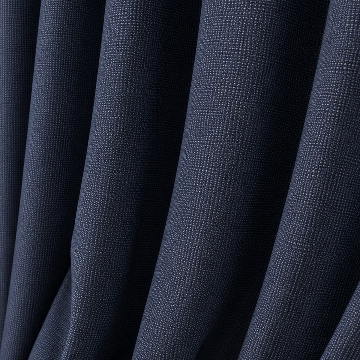 A close-up of dark navy blue textured fabric with soft vertical folds.